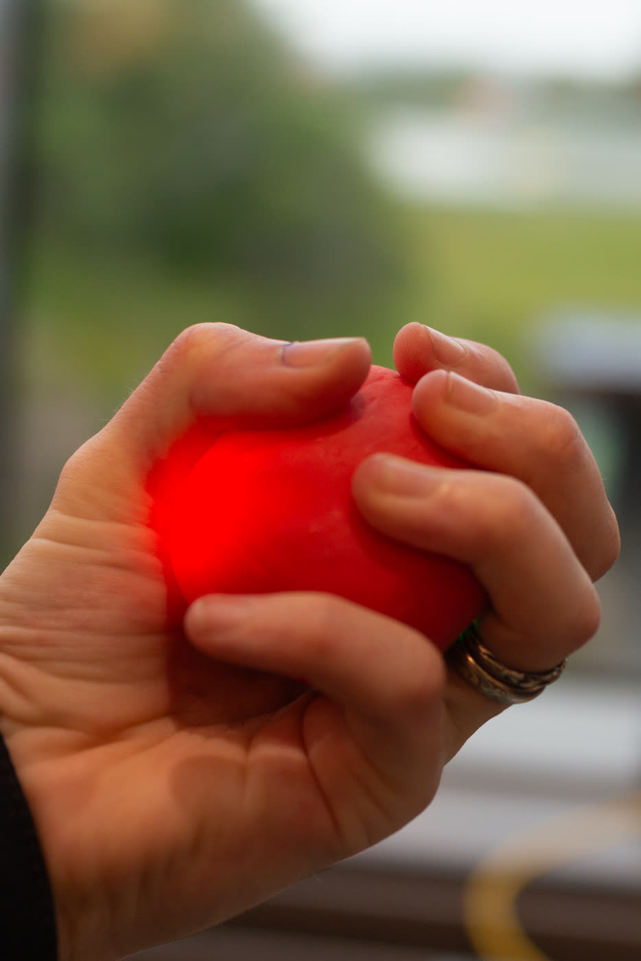 Love Is (2024): a hand holding a glowing heart-machine