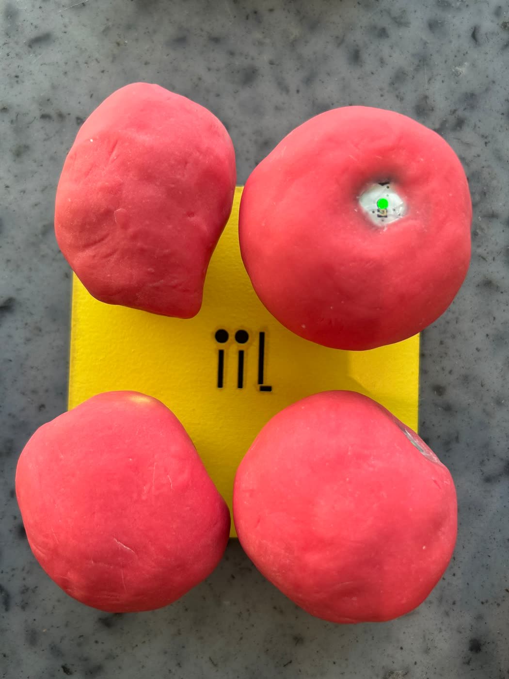Four red heart-machines on a yellow plate, one with its green light on